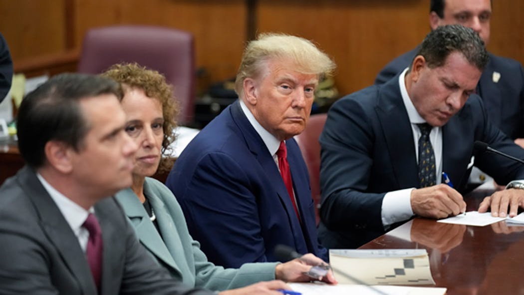 Former President Donald Trump sits at the defense table