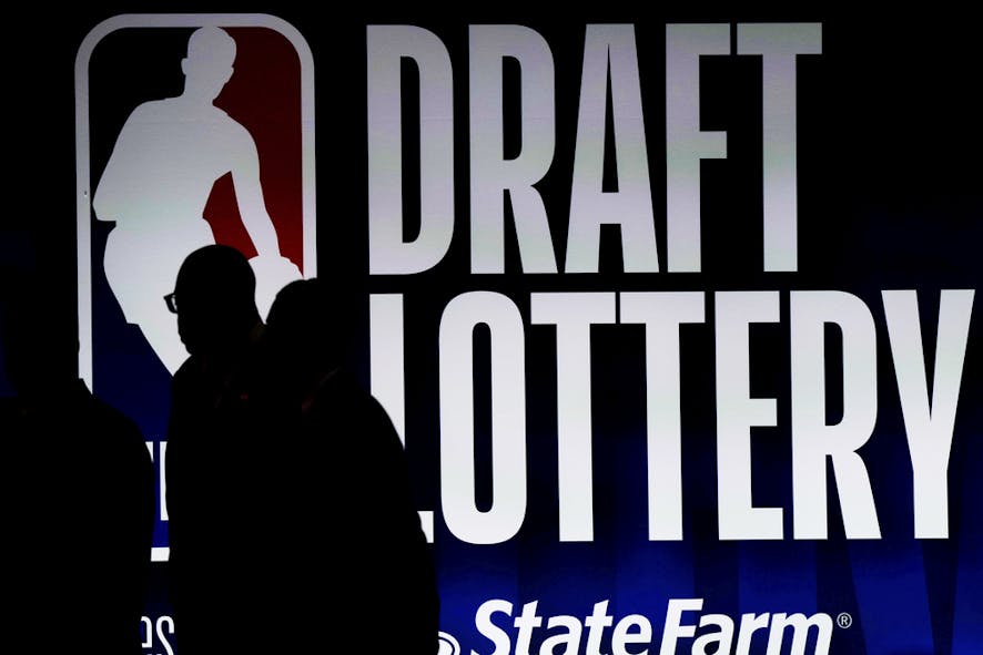 People walk by a sign during the NBA basketball draft lottery 