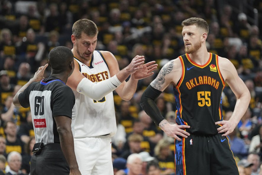 Nikola Jokic, center, talks with referee James Williams
